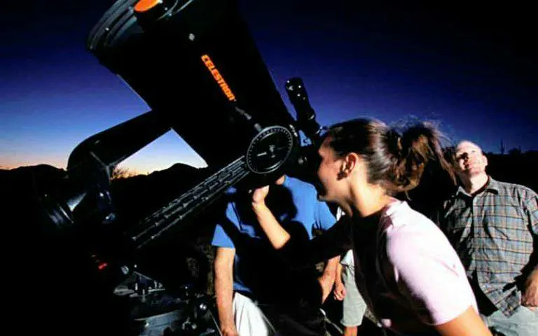 People stargazing through a telescope at Teide National Park, Tenerife during sunset tour.