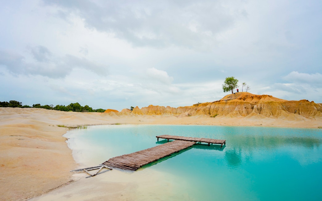 Wooden pier over turquoise water at Blue Lake, Bintan Mini Desert.