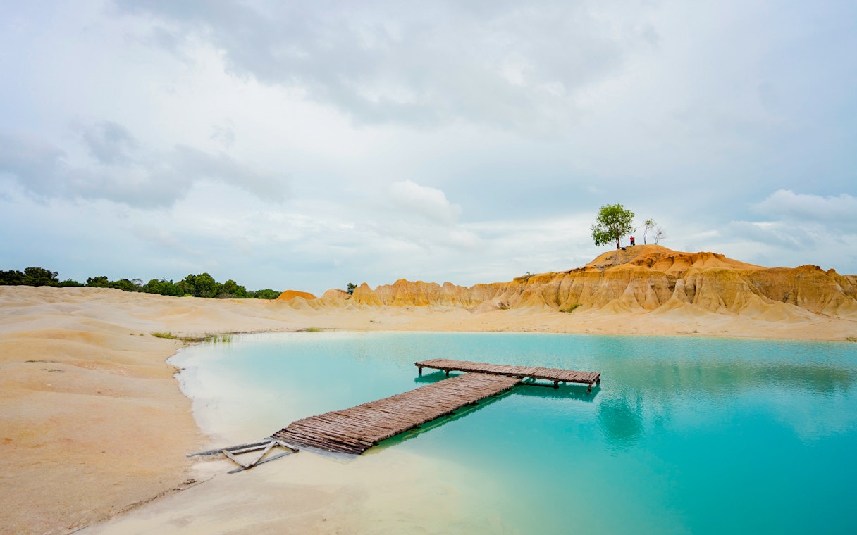 Wooden pier over turquoise water at Blue Lake, Bintan Mini Desert.