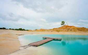 Wooden pier over turquoise water at Blue Lake, Bintan Mini Desert.