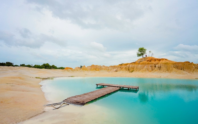 Wooden pier over turquoise water at Blue Lake, Bintan Mini Desert.
