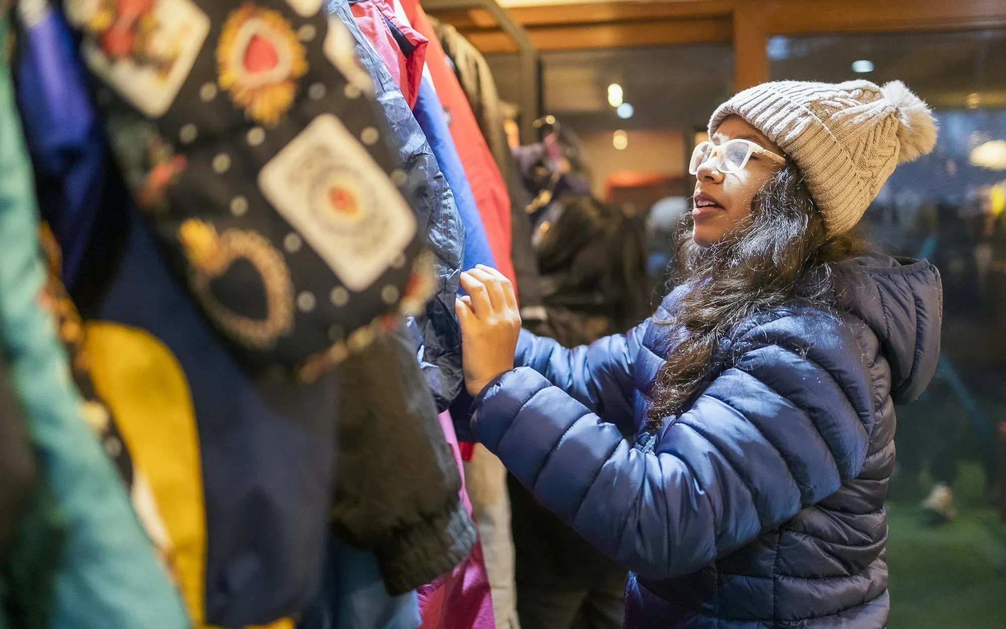 Tourist browsing winter clothing at Valle Nevado ski resort store, Chile.