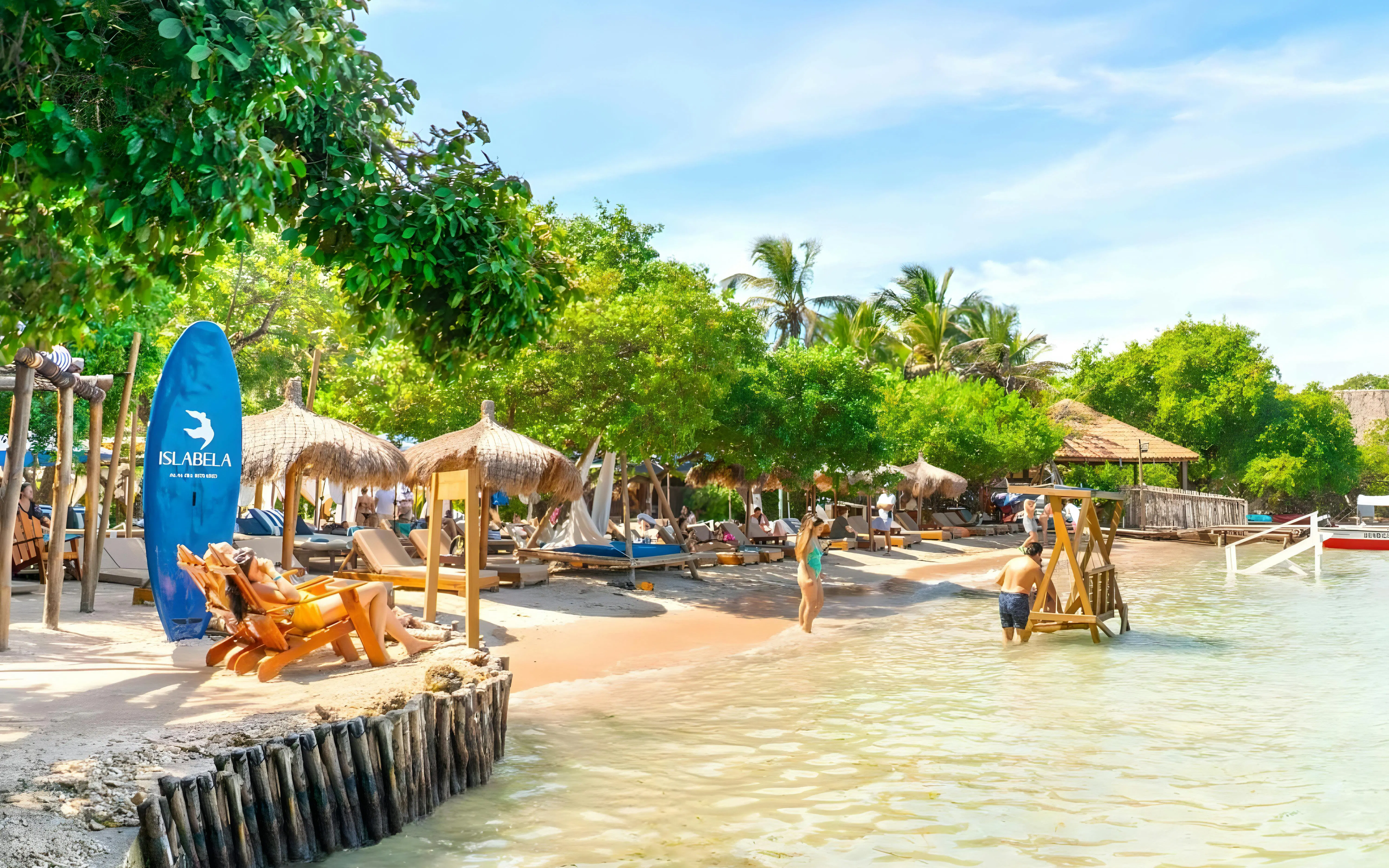 Beachfront with lounge chairs and palm trees on a beach island in the Rosario Islands near Cartagena, Colombia.