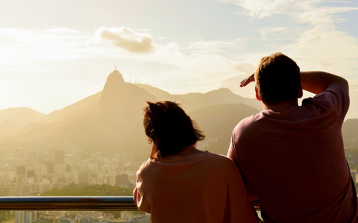 Couple viewing Christ the Redeemer from Sugarloaf Mountain, Rio de Janeiro.
