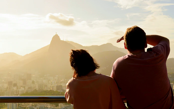 Couple viewing Christ the Redeemer from Sugarloaf Mountain, Rio de Janeiro.