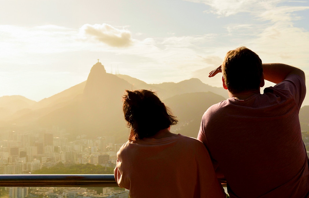 Couple viewing Christ the Redeemer from Sugarloaf Mountain, Rio de Janeiro.