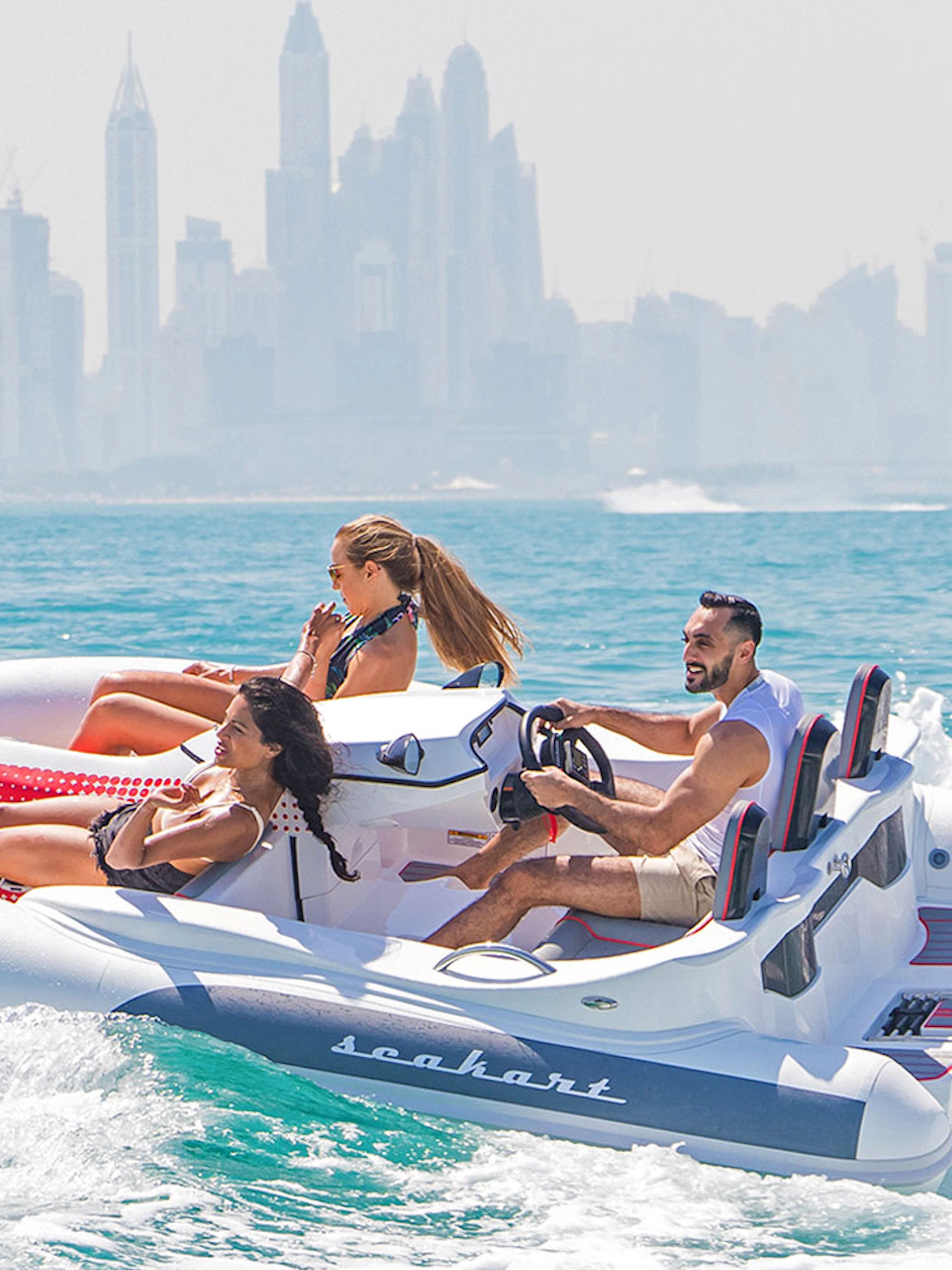 Group enjoying SeaKart jet ski tour in Dubai Marina with city skyline in background.