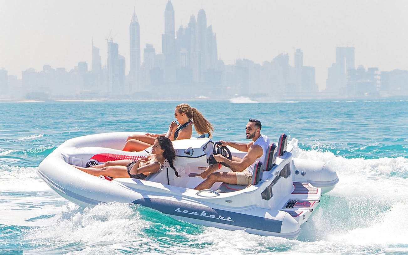 Group enjoying SeaKart jet ski tour in Dubai Marina with city skyline in background.