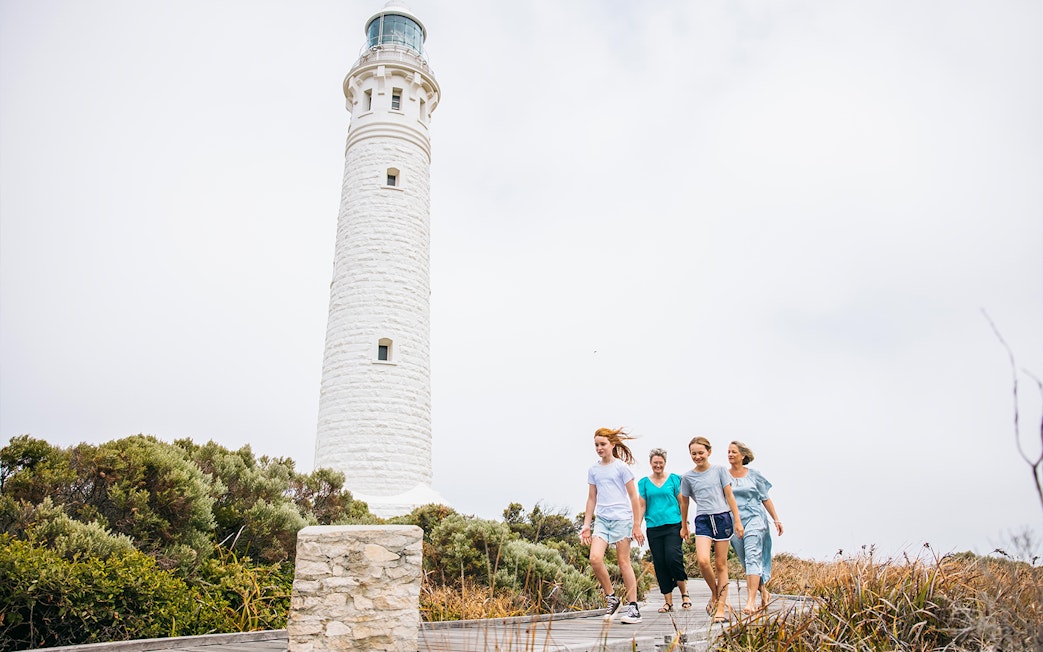 Family walking on boardwalk near Cape Leeuwin Lighthouse, Australia.
