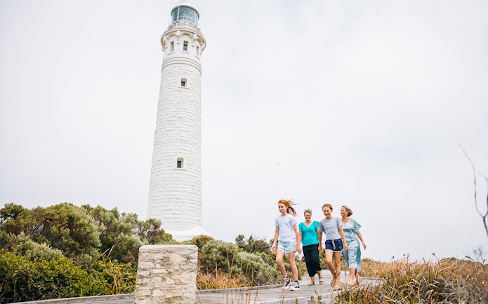 Family walking on boardwalk near Cape Leeuwin Lighthouse, Australia.