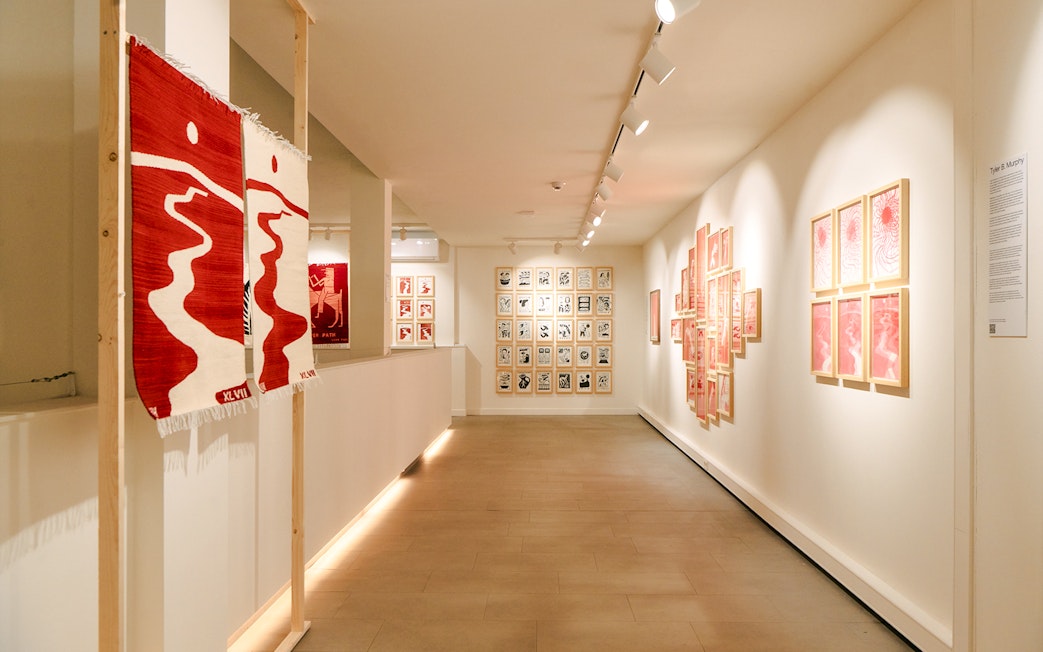 Exhibition hallway with red and white art pieces at Family & Legacy, Straat Museum.