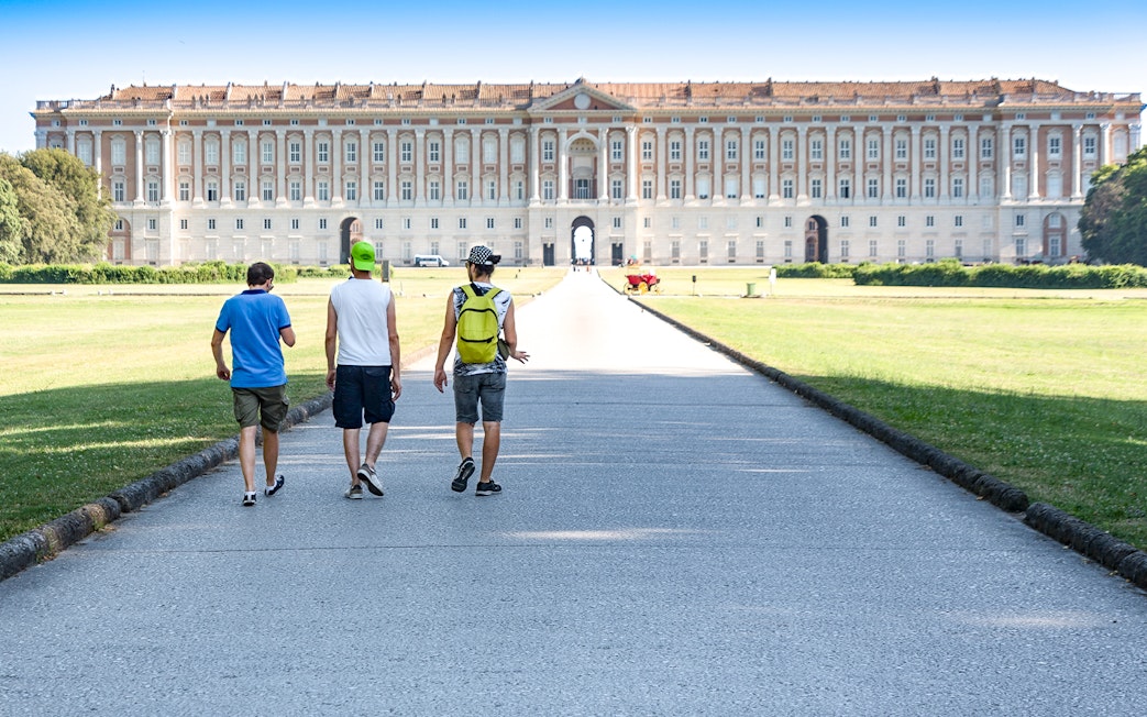 Visitors walking towards the Royal Palace of Caserta in Italy.