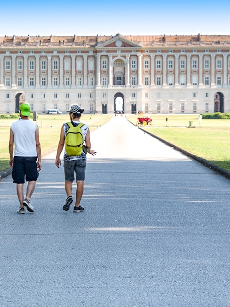 Visitors walking towards the Royal Palace of Caserta in Italy.