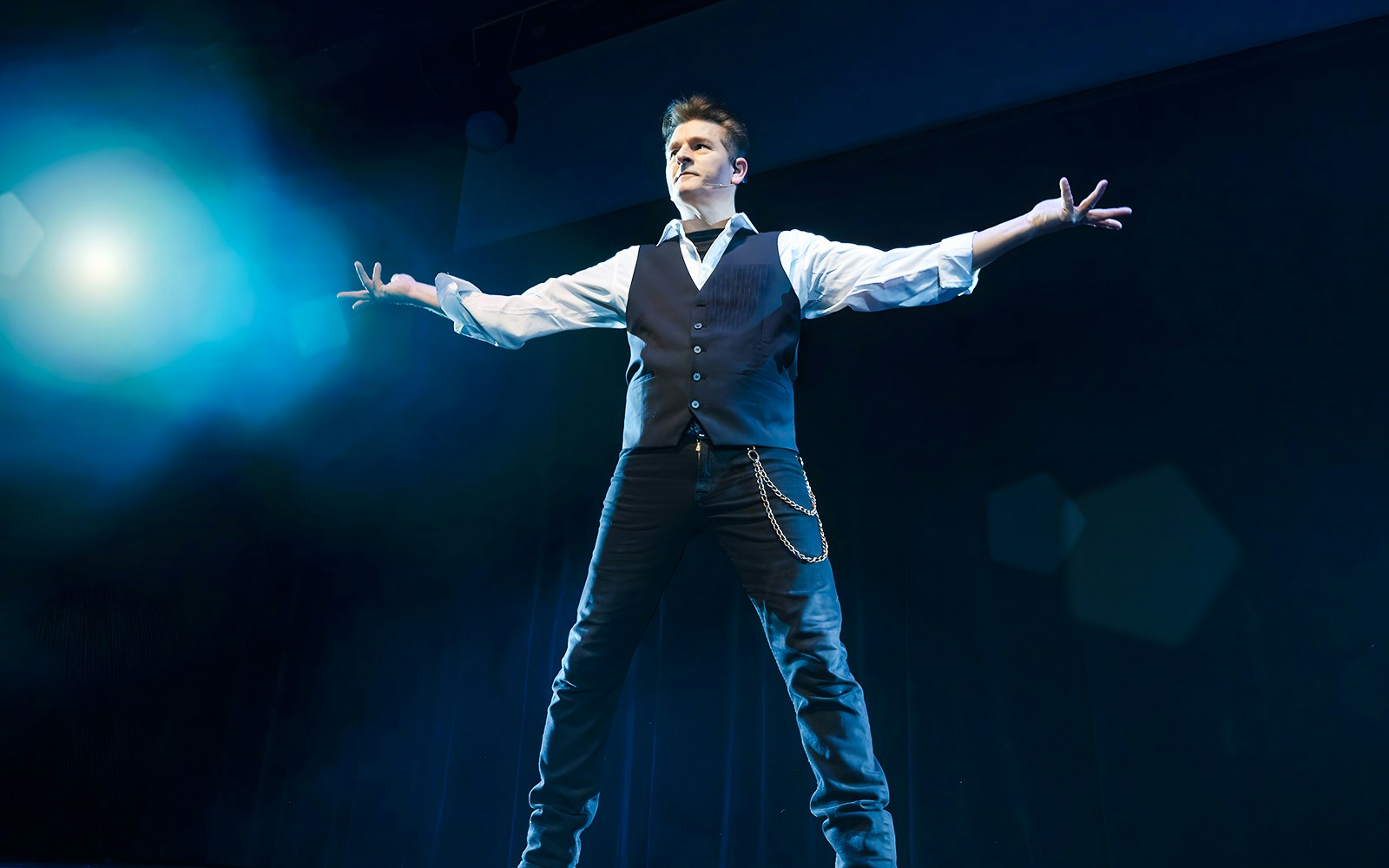 Magician performing on stage during the Evolution Magic Show.