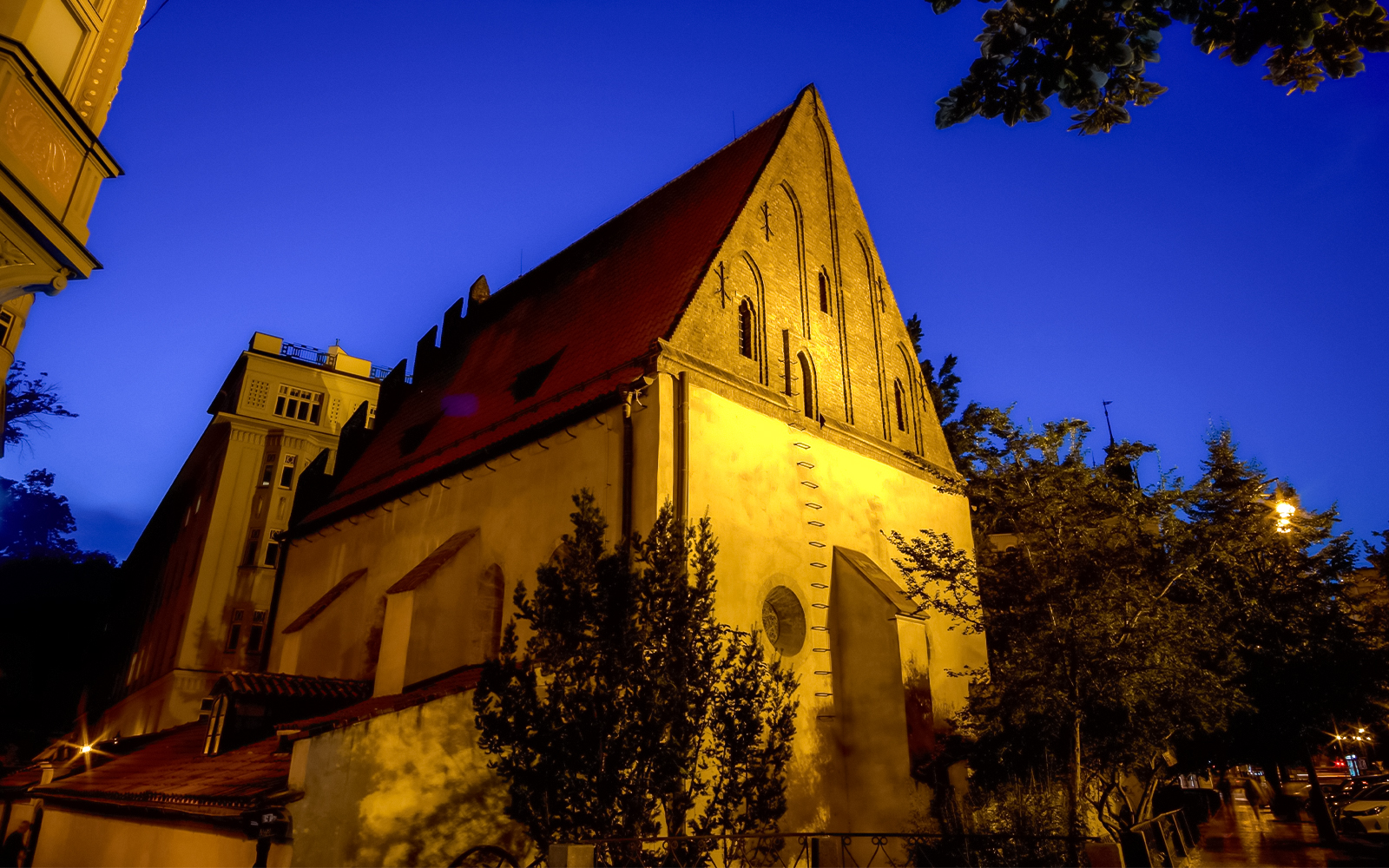 Old New Synagogue illuminated at night in Prague's Jewish Quarter.