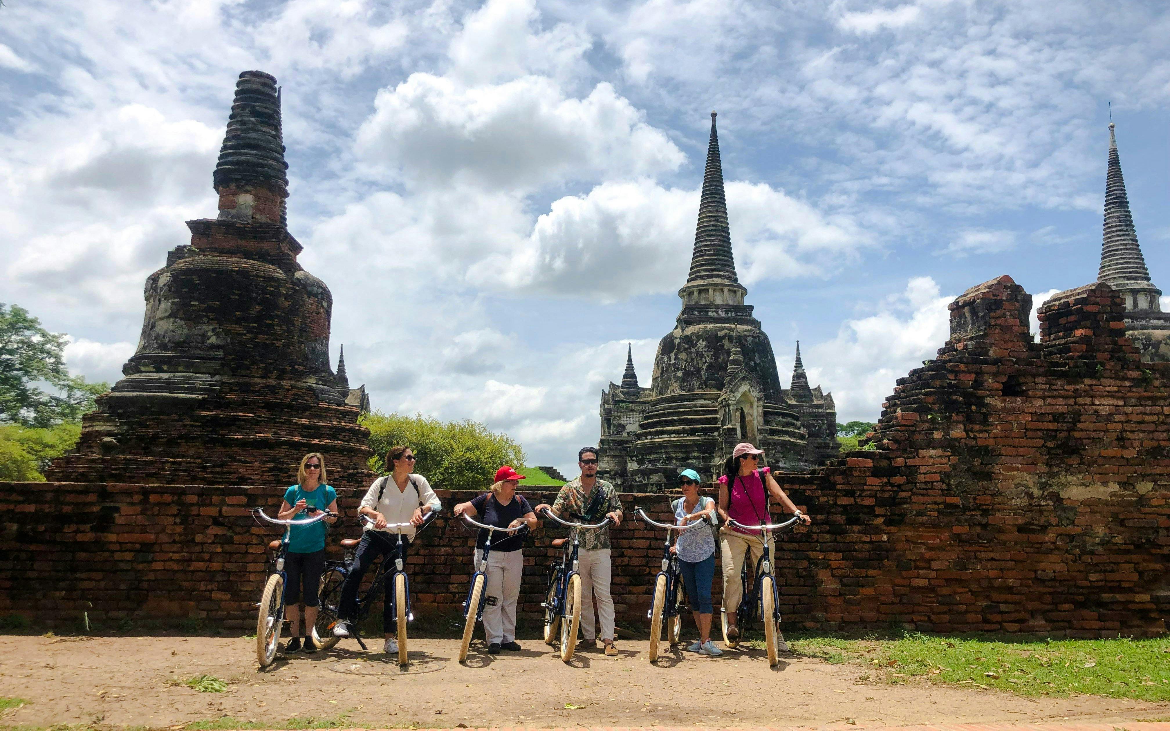 Cyclists exploring ancient ruins in Ayutthaya, Thailand.