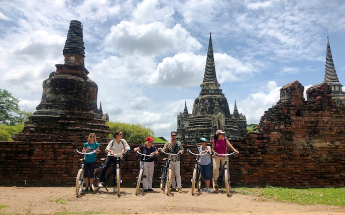 Cyclists exploring ancient ruins in Ayutthaya, Thailand.