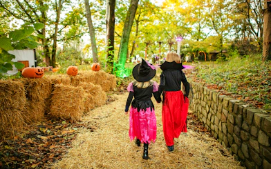Children in Halloween costumes walking through decorated path at Heide Park.