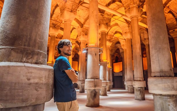 Man standing among columns in Basilica Cistern, Istanbul.