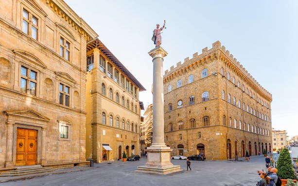 Column of Justice in Piazza Santa Trinita, Florence, with historic buildings.
