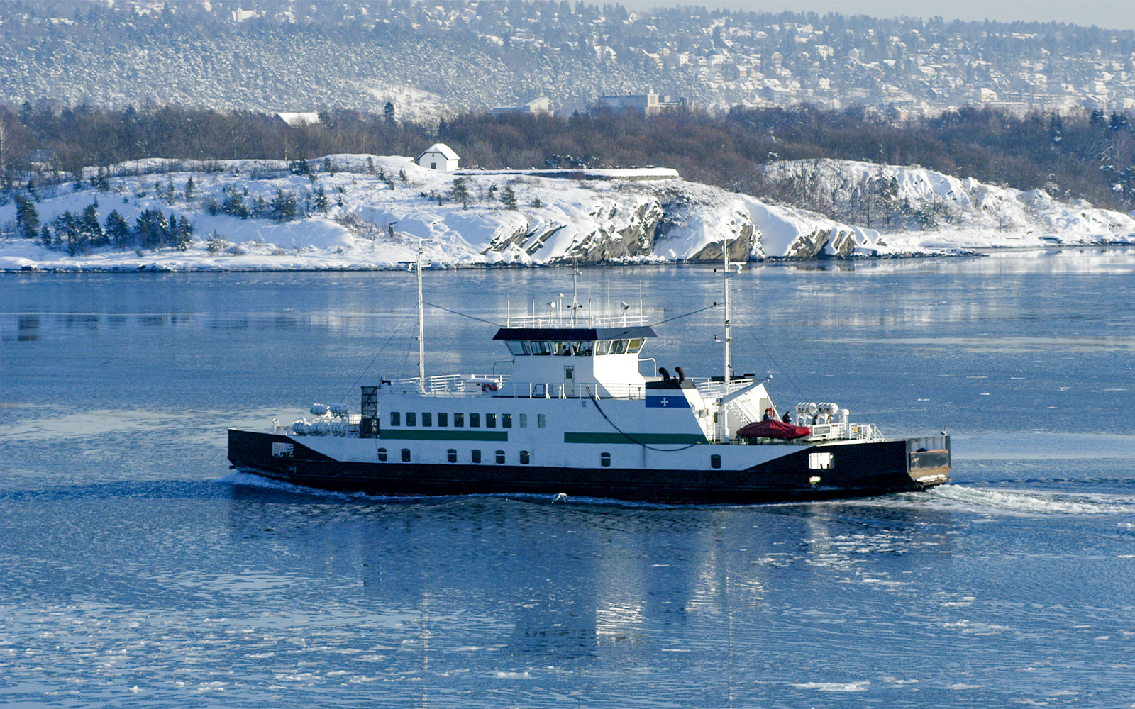 Oslo Fjord winter cruise with snow-covered islands and serene sea views.