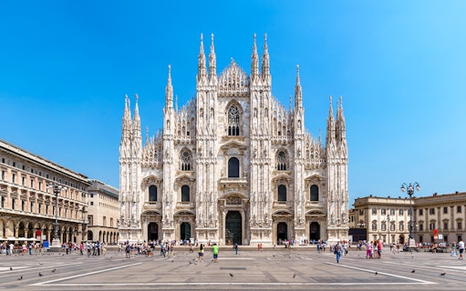 Milan Cathedral facade with tourists in Piazza del Duomo, Italy.