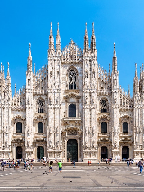 Milan Cathedral facade with tourists in Piazza del Duomo, Italy.