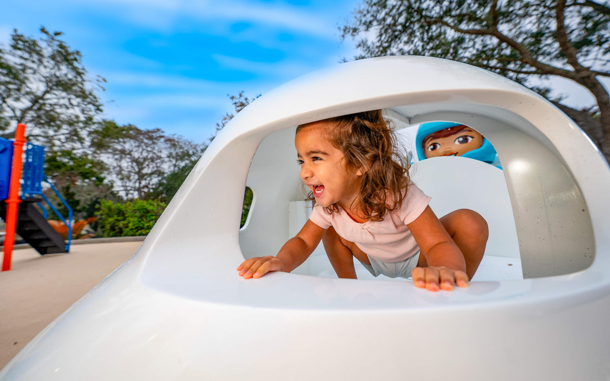 Child playing in a spaceship-themed playground at LEGOLAND California Resort.
