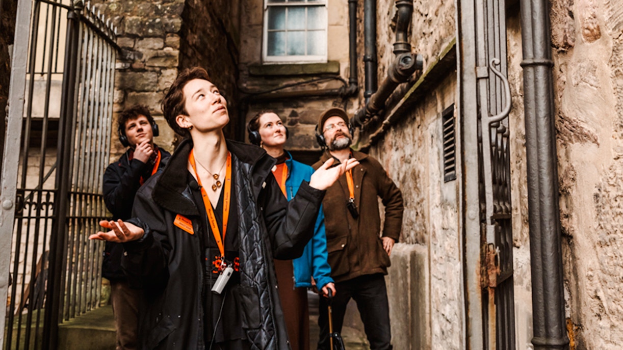 Tour group exploring a narrow alley on the Secrets of the Royal Mile Tour in Edinburgh.
