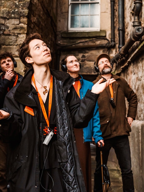 Tour group exploring a narrow alley on the Secrets of the Royal Mile Tour in Edinburgh.