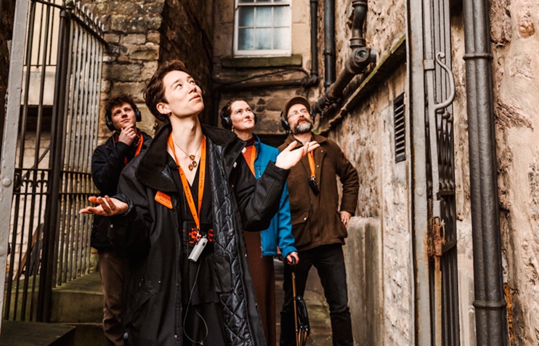Tour group exploring a narrow alley on the Secrets of the Royal Mile Tour in Edinburgh.