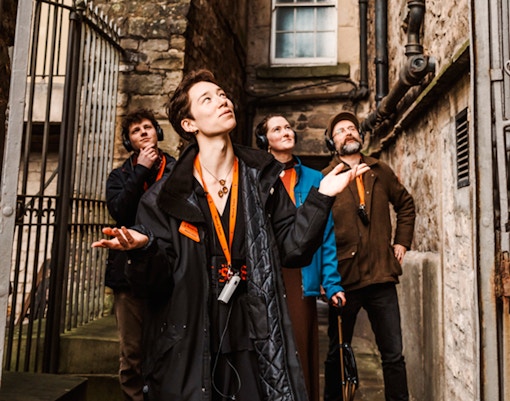 Tour group exploring a narrow alley on the Secrets of the Royal Mile Tour in Edinburgh.
