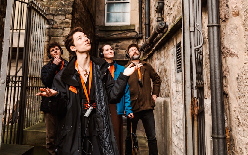 Tour group exploring a narrow alley on the Secrets of the Royal Mile Tour in Edinburgh.