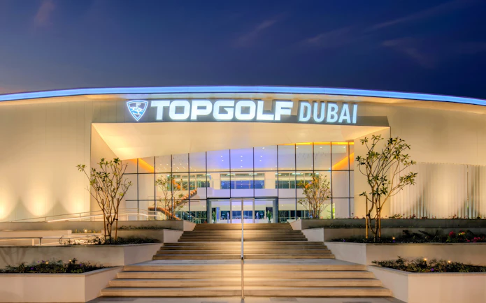 Topgolf Dubai entrance illuminated at night.