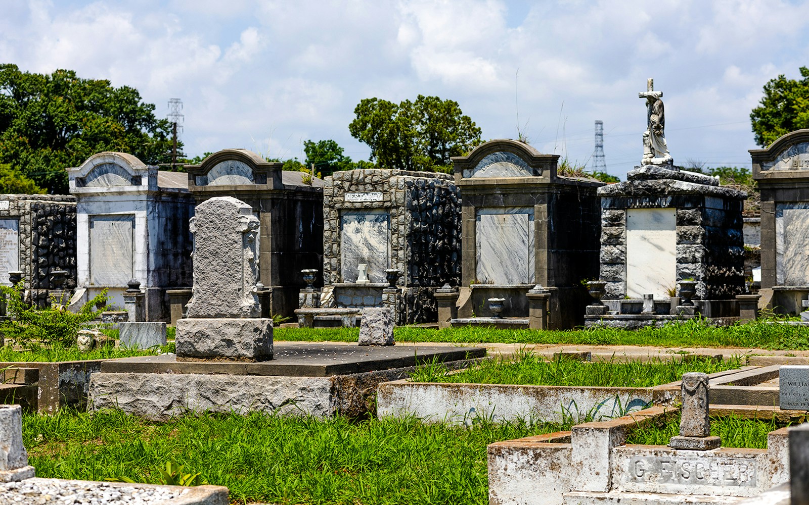 New Orleans cemetery with historic above-ground tombs and statues.