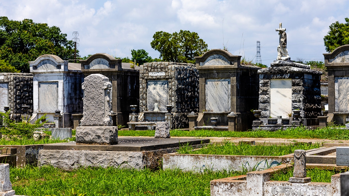 New Orleans cemetery with historic above-ground tombs and statues.