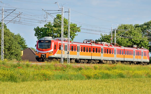 Modern Polish train traveling through countryside.