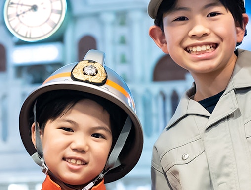 Children in firefighter and worker uniforms at Kidzania Tokyo.