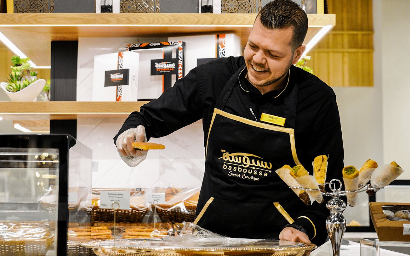 Man serving pastries at Depachika food hall, Palm Jumeirah.