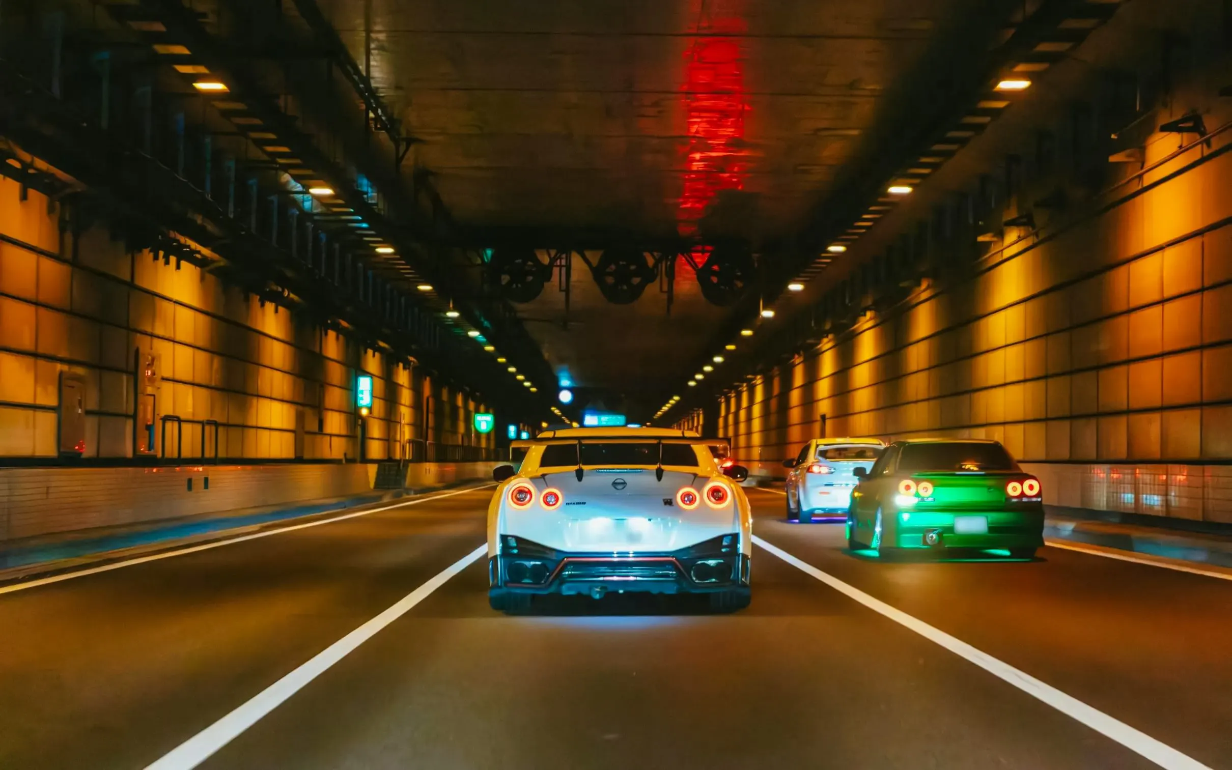 Cars racing through a lit Tokyo tunnel for Fast & Furious Tokyo Drift III Experience.