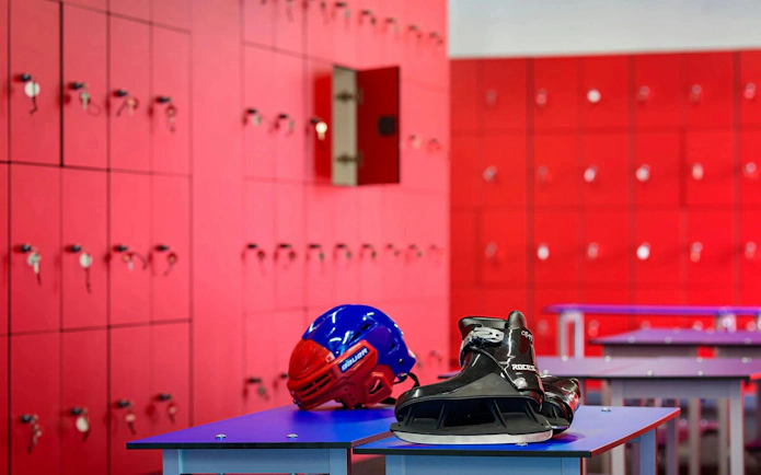 FC Barcelona Ice Rink locker room with helmet and skates on bench.