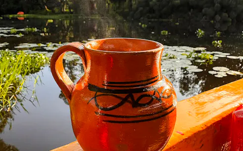 Ceramic jug on a trajinera boat at sunrise in Xochimilco, Mexico City.