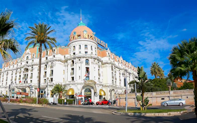 Hotel Negresco's grand facade with palm trees, Nice City.