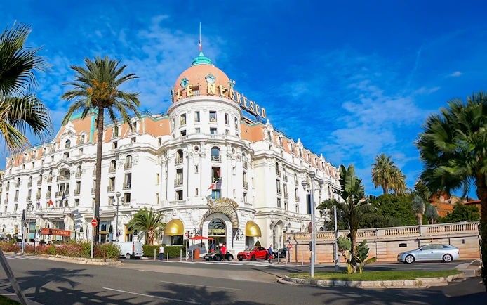 Hotel Negresco's grand facade with palm trees, Nice City.