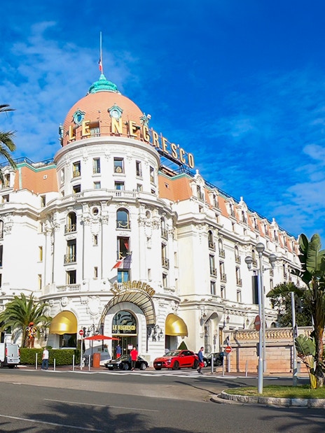 Hotel Negresco's grand facade with palm trees, Nice City.