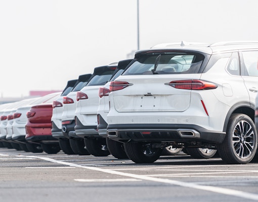 Secure car parking area with multiple parked vehicles in a city setting.