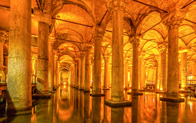 Ancient columns and arches inside the illuminated Basilica Cistern in Istanbul.