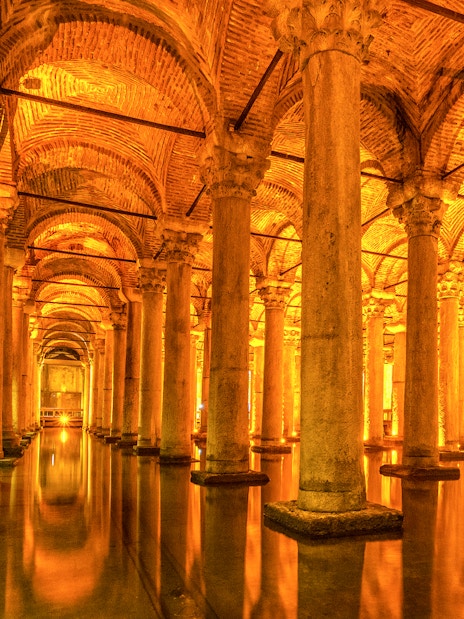 Ancient columns and arches inside the illuminated Basilica Cistern in Istanbul.