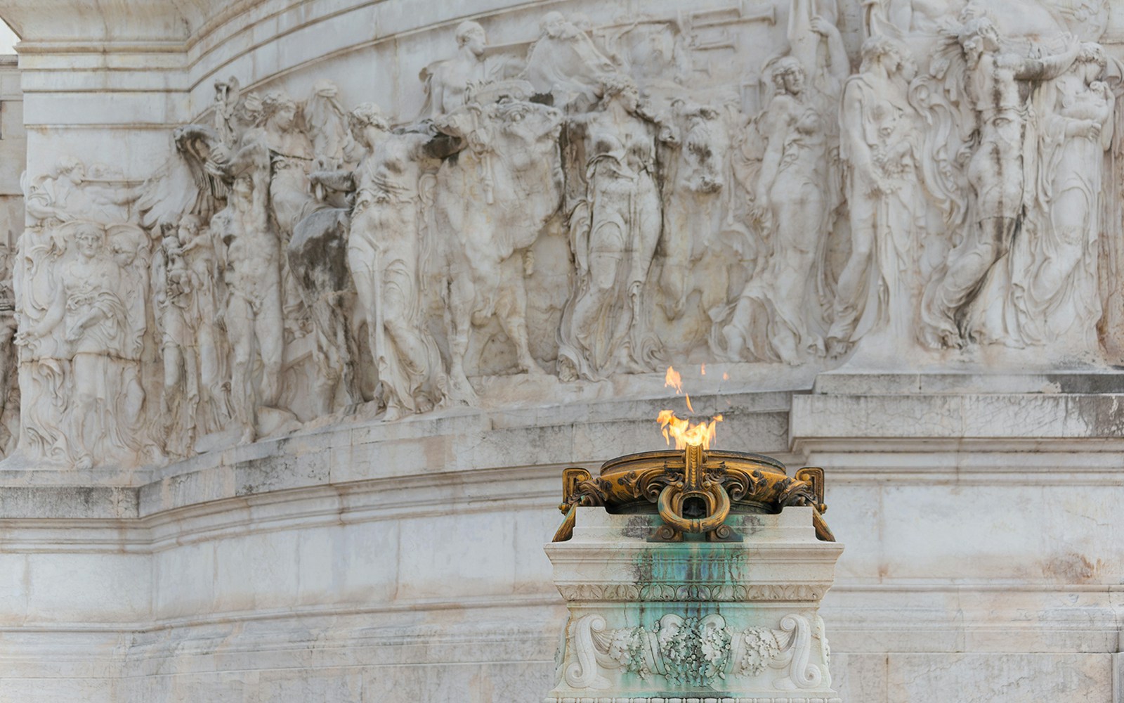 Tomb of the Unknown Soldier in Rome with Italian flag in background.