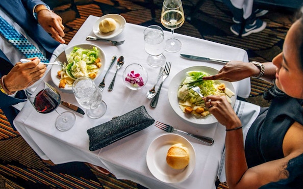 Guests dining on Odyssey Lake Michigan Dinner Cruise with salads and wine.